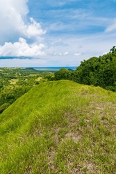 Vibrant Grass-covered Hills Of Mabini, Bohol, With A Panoramic View Of The Sea And Sky In The Philippines.