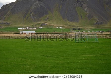 Vibrant green fields with a backdrop of mountains in Akranes, Iceland