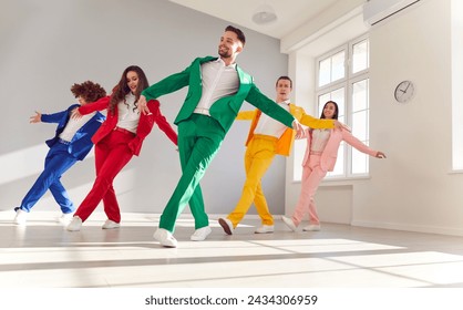 Vibrant group of a dancing people in colorful business suits, smiling as they dance energetically. The lively atmosphere and upbeat music create a joyous dance party with a happy crowd of dancers. - Powered by Shutterstock