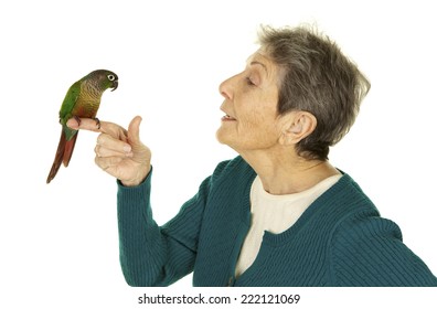 Vibrant Happy Senior Woman On A White Background Talking To Her Pet Bird