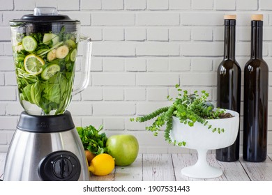 Vibrant healthy green smoothie with a blender in the background on a wooden table - Powered by Shutterstock