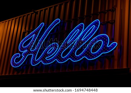 A Vibrant Hello Sign Against a Container Lihgts up the Night
