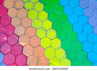 Vibrant hexagonal tiles form a rainbow gradient. Colors shift smoothly from pink to deep blue. Pattern feels modern, playful, and eye-catching. Ideal for design, fashion, or digital backgrounds