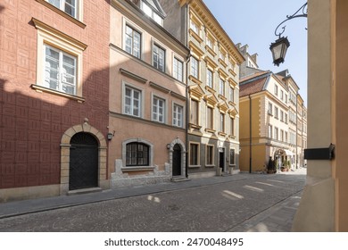 A vibrant historic street in the old town, featuring colorful buildings with arched doorways and cobblestone paths. The charming urban scene showcases classic European architecture. - Powered by Shutterstock