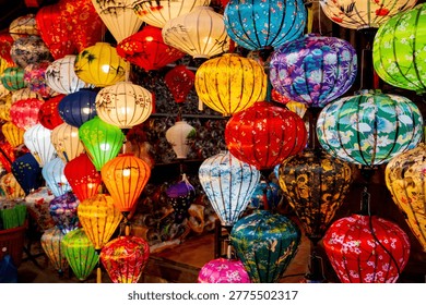 Vibrant, intricately patterned lanterns in assorted shapes and colors hang gracefully along a timeworn Vietnam market, showcasing exquisite traditional artistry.