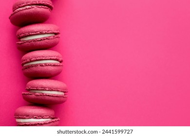 Vibrant macarons lined up on a vivid pink background - Powered by Shutterstock