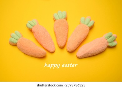 Vibrant marshmallow carrots in a creative Easter display, forming a decorative fan shape on a warm yellow background with a ‘Yappy Easter’ greeting. A cheerful treat for holiday designs. sstkEaster.