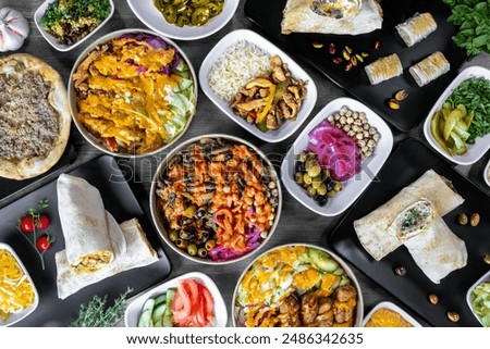 Vibrant Mediterranean feast featuring an array of dishes including wraps, salads, grilled meats, and fresh vegetables. This colorful spread showcases the rich flavors and diverse ingredients.