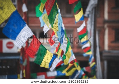 Vibrant multicolored Buddhist prayer flags hang strung across an outdoor area in Kathmandu Nepal