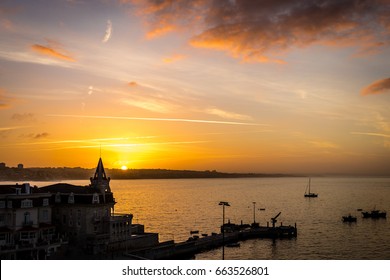Vibrant orange sky as the sun rises over Cascais Marina in Cascais, Portugal. Popular European holiday destination,  