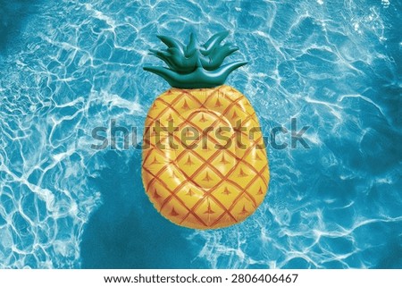A vibrant pineapple-shaped inflatable pool float rests on the surface of a clear, blue swimming pool, with sunlight creating shimmering patterns on the water.