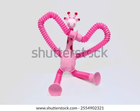 A vibrant pink giraffe toy with flexible, twistable limbs made of spring-like material. Perfect for children's playtime, providing entertainment and imaginative fun.