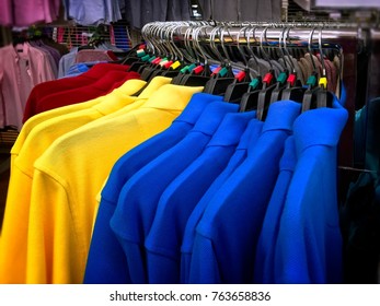 Vibrant Polo Shirts Hanging On Curved Steel Rack