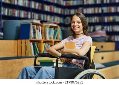 Vibrant portrait of young female student with disability looking at camera in college library and smiling - Powered by Shutterstock