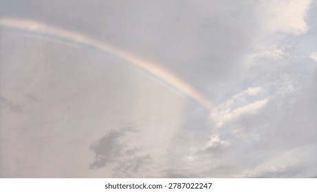 Vibrant Rainbow Arching Across Dramatic Evening Sky After Rain with Warm Golden Hour Natural Light Wide Landscape Photography Style for Nature and Weather Commercial Use