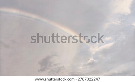 Vibrant Rainbow Arching Across Dramatic Evening Sky After Rain with Warm Golden Hour Natural Light Wide Landscape Photography Style for Nature and Weather Commercial Use