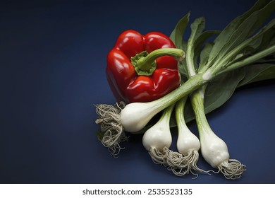 A vibrant red bell pepper with a shiny, glossy surface placed against a dark blue background - Powered by Shutterstock