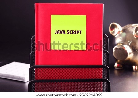 A vibrant red book titled JavaScript stands upright in a black metal organizer beside a golden piggy bank, emphasizing the theme of programming and finance.