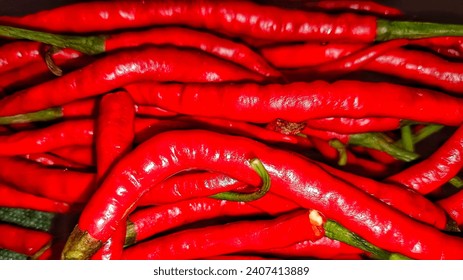 Vibrant red trails of curly chili up close. The fiery hue exudes a captivating visual, hinting at warmth and a spicy flavor ready to tantalize the taste buds. #ChiliPepper #FieryRed #Spicy