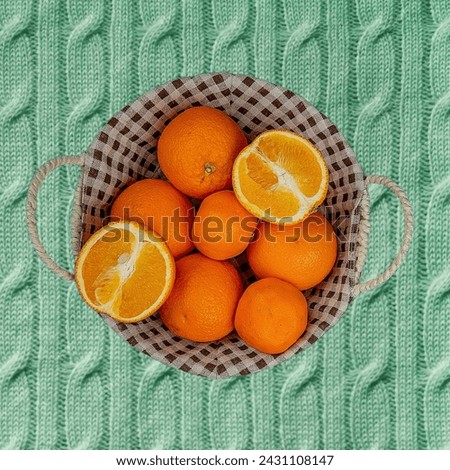 Vibrant scene featuring a basket filled with fresh oranges set against a lush green blanket, evoking a sense of natural beauty and wholesome simplicity. #orangefruit 🍊