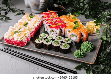 Vibrant selection of sushi presented with greenery, wasabi, and soy sauce on a sleek surface - Powered by Shutterstock