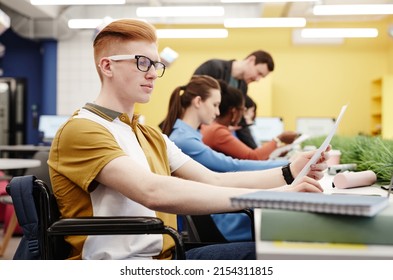 Vibrant side view portrait of red haired young man with disability studying in college, copy space - Powered by Shutterstock