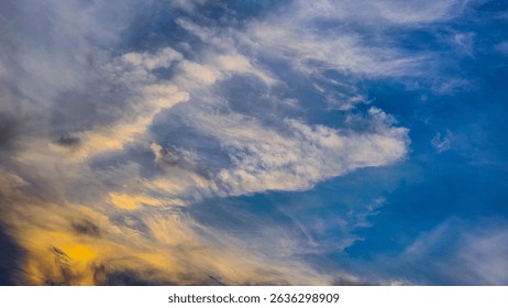 A vibrant sky during sunset with dramatic cloud formations and a gradient of warm and cool tones. A natural abstract scene full of color and movement.