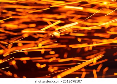 Vibrant sparks flying from metalwork in a dark workshop environment. Bright orange sparks illuminate the air during metalworking - Powered by Shutterstock