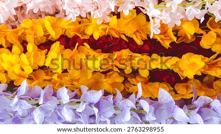 a vibrant stack of flower leis in various colors