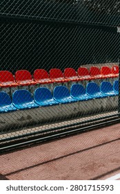Vibrant stadium seating viewed through a chain-link fence