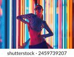 Vibrant street style. Portrait of woman wearing uniquely top and trendy eyeglasses, with vividly colorful neon striped background. Concept of youth, beauty, fashion and style, modern lifestyle. Ad