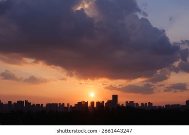 Vibrant Sunset with Dramatic Clouds Above City Skyline Silhouette