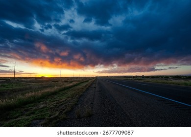 Vibrant sunset illuminates empty interstate highway in rural Texas panhandle USA