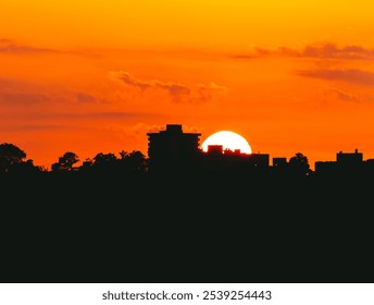 A Vibrant Sunset Over A City Skyline With Silhouetted Buildings And Trees, Casting A Beautiful Glow That Highlights The Urban Landscape And Creates A Stunning Evening Atmosphere. - Powered by Shutterstock