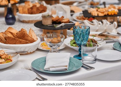 A vibrant table adorned with an array of scrumptious food awaits guests. Plates are filled with savory dishes, fresh salads, and homemade bread, creating a warm atmosphere for celebration.