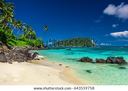 Vibrant tropical Lalomanu beach on Samoa Island with coconut palm trees and black rocks