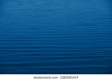 Vibrant turquoise ocean. Clear deep Mediterranean water in summer. Aerial view of blurry wave. Textured background backdrop. Cool evening by lake. Vivid blue color. Dark sea. Smooth elegant motion. - Powered by Shutterstock