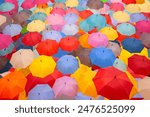 Vibrant Umbrella Canopy - A Kaleidoscope of Colors and Patterns Overhead. A display of countless colorful umbrellas creating a canopy overhead. Concepts, diversity, togetherness, and vibrancy.