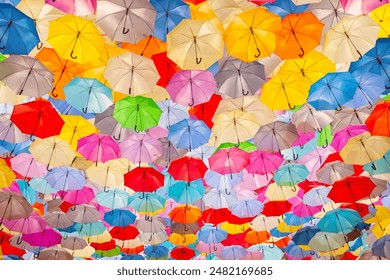 Vibrant Umbrella Canopy - A Kaleidoscope of Colors and Patterns Overhead. A display of countless colorful umbrellas creating a canopy overhead. Concepts, diversity, togetherness, and vibrancy. - Powered by Shutterstock