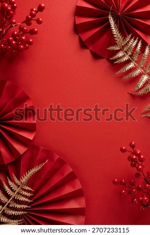 Vibrant vertical red backdrop with round paper fans, red berries, and gold fern sprigs, embodying Chinese New Year spirit with festive charm ideal for greeting cards and seasonal promotions