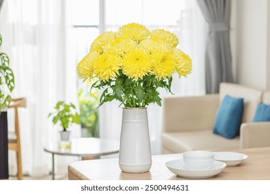 Vibrant Vragen aan Magnum Yellow (Super Magnum Chrysanthemum) flowers elegantly arranged in a white vase, beautifully decorating a dining table. Ideal for adding color and elegance to any meal. - Powered by Shutterstock