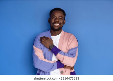 Vibrant waist up portrait of young black man smiling at camera and wearing colorful clothes - Shutterstock ID 2314475633