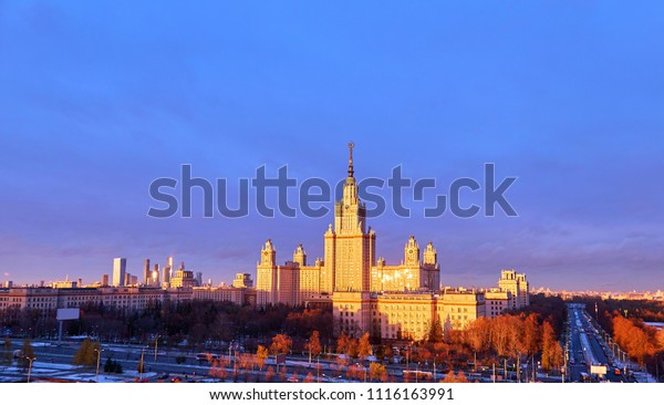 Vibrant wide angle panoramic view of sunset\
campus of famous Moscow  university under dramatic sky in spring\
with bright window reflections\

