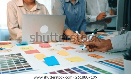 A vibrant workspace setup showcasing a team collaborating with color swatches and notes, highlighting creativity and ideation process for design concepts and project planning. SACTR