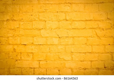 Vibrant yellow brick wall as a background image with vignette