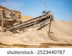 Vibrating screen stone crusher in operation. Crushing stones in a quarry for processing minerals, cement, limestone. Heavy and mobile equipment in a quarry for processing stone into building material.