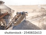 Vibrating screen stone crusher in operation. Crushing stones in a quarry for processing minerals, cement, limestone. Heavy and mobile equipment in a quarry for processing stone into building material.