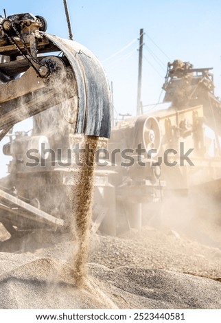 Vibrating screen stone crusher in operation. Crushing stones in a quarry for processing minerals, cement, limestone. Heavy and mobile equipment in a quarry for processing stone into building material.