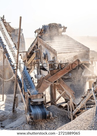 Vibrating screen stone crusher in operation. Crushing stones in a quarry for processing minerals, cement, limestone. Heavy and mobile equipment in a quarry for processing stone into building material.