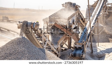 Vibrating screen stone crusher in operation. Crushing stones in a quarry for processing minerals, cement, limestone. Heavy and mobile equipment in a quarry for processing stone into building material.